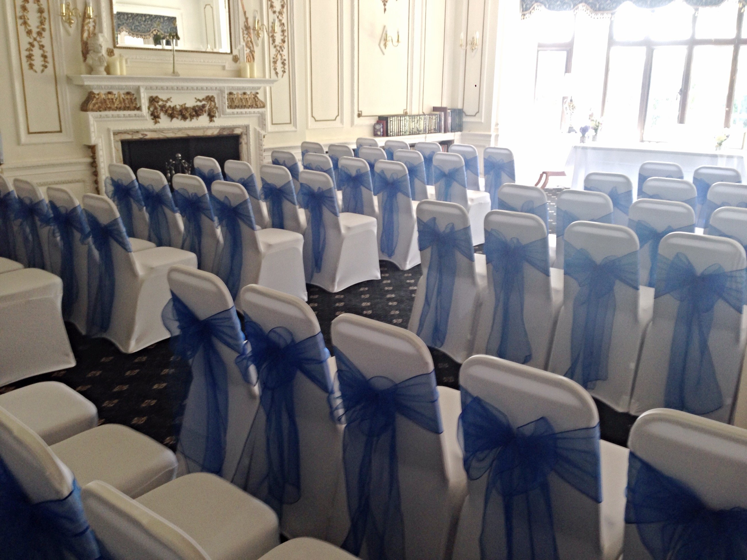 Navy organza sashes and white lycra chair covers and De Rougement Manor